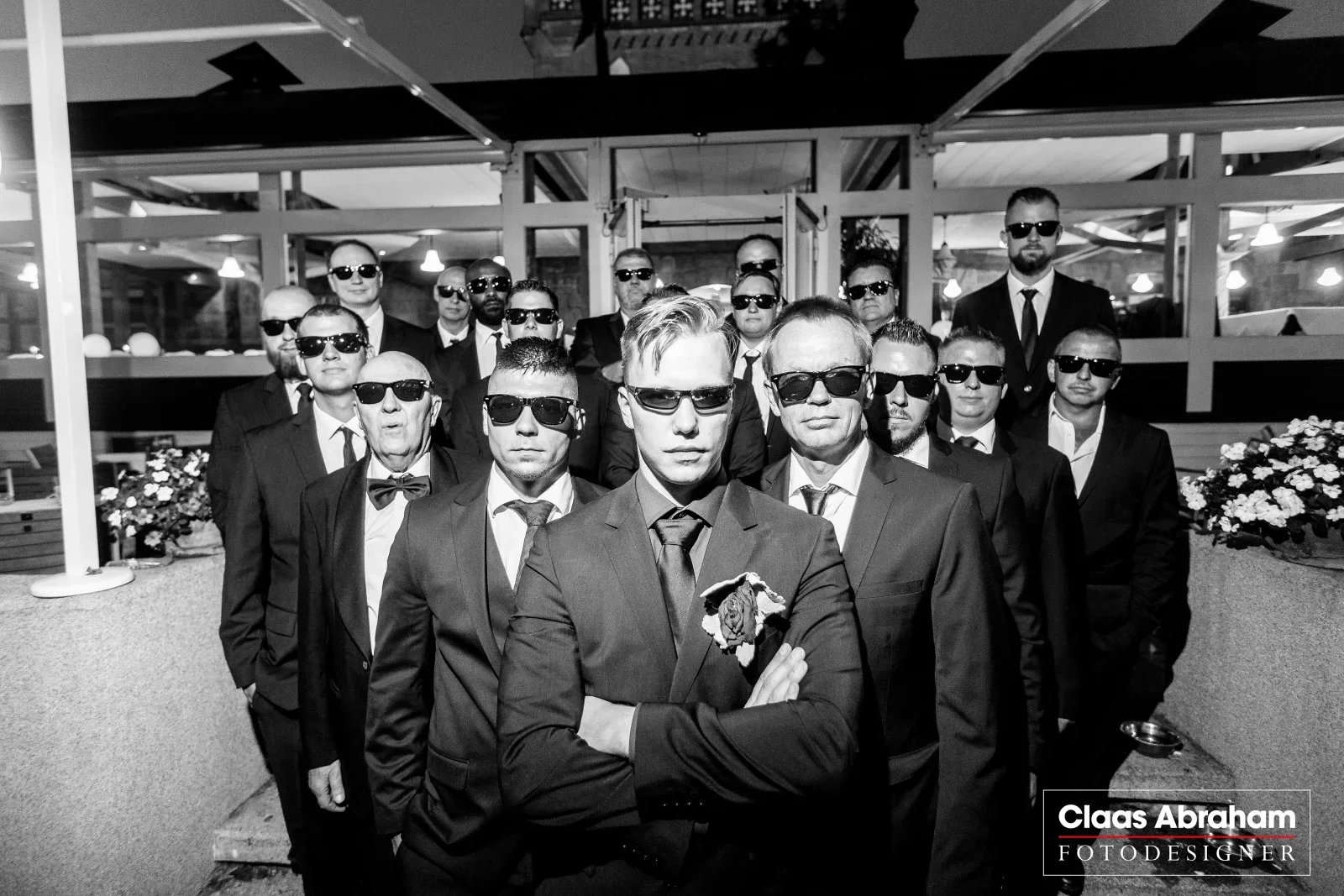 Eine Männergruppe posiert gemeinsam mit Sonnenbrillen für ein humorvolles Gruppenfoto.