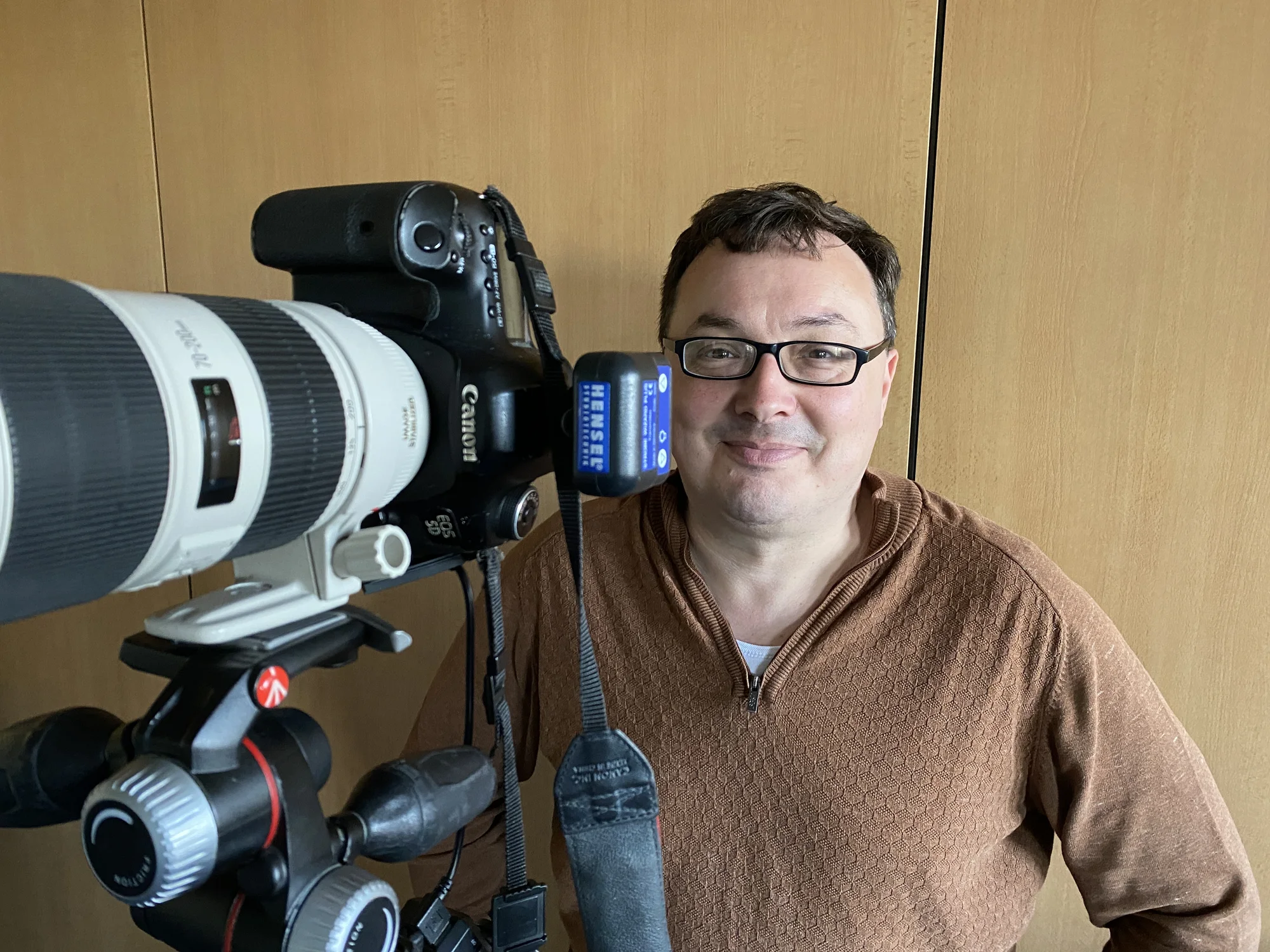 Fotograf Claas Abraham neben seiner Kamera mit Teleobjektiv.