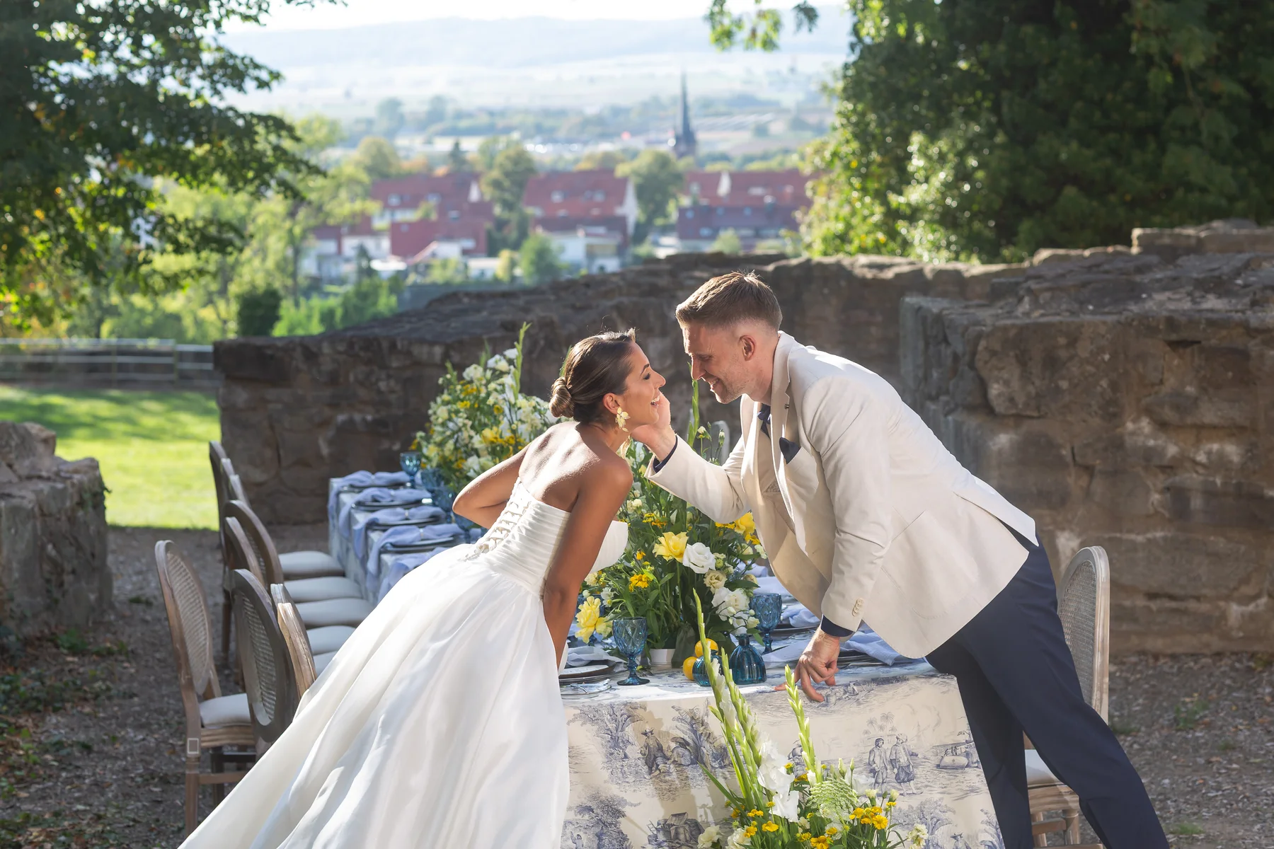 Ein Hochzeitspaar begegnet sich an einer festlich gedeckten Tafel im Abendlicht.