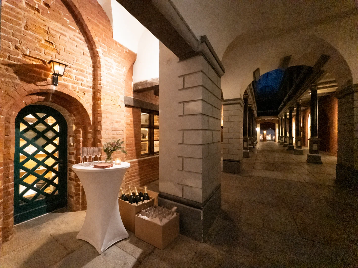 Vorbereiteter Stehtisch mit Sektgläsern, Flaschen und Servietten vor dem Eingang des Fotostudios im Stralsunder Rathaus.
